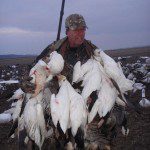Happy hunter with a game strap full of snow geese.