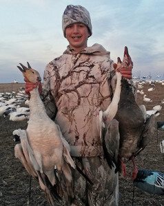 Youth Snow Goose Hunter proudly showing his geese.
