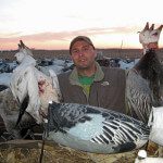 This hunter poses with some of the snow and blue geese he harvested.